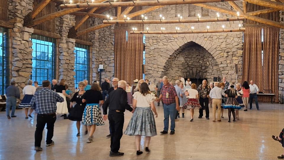 Several squares of dancers on the lodge floor