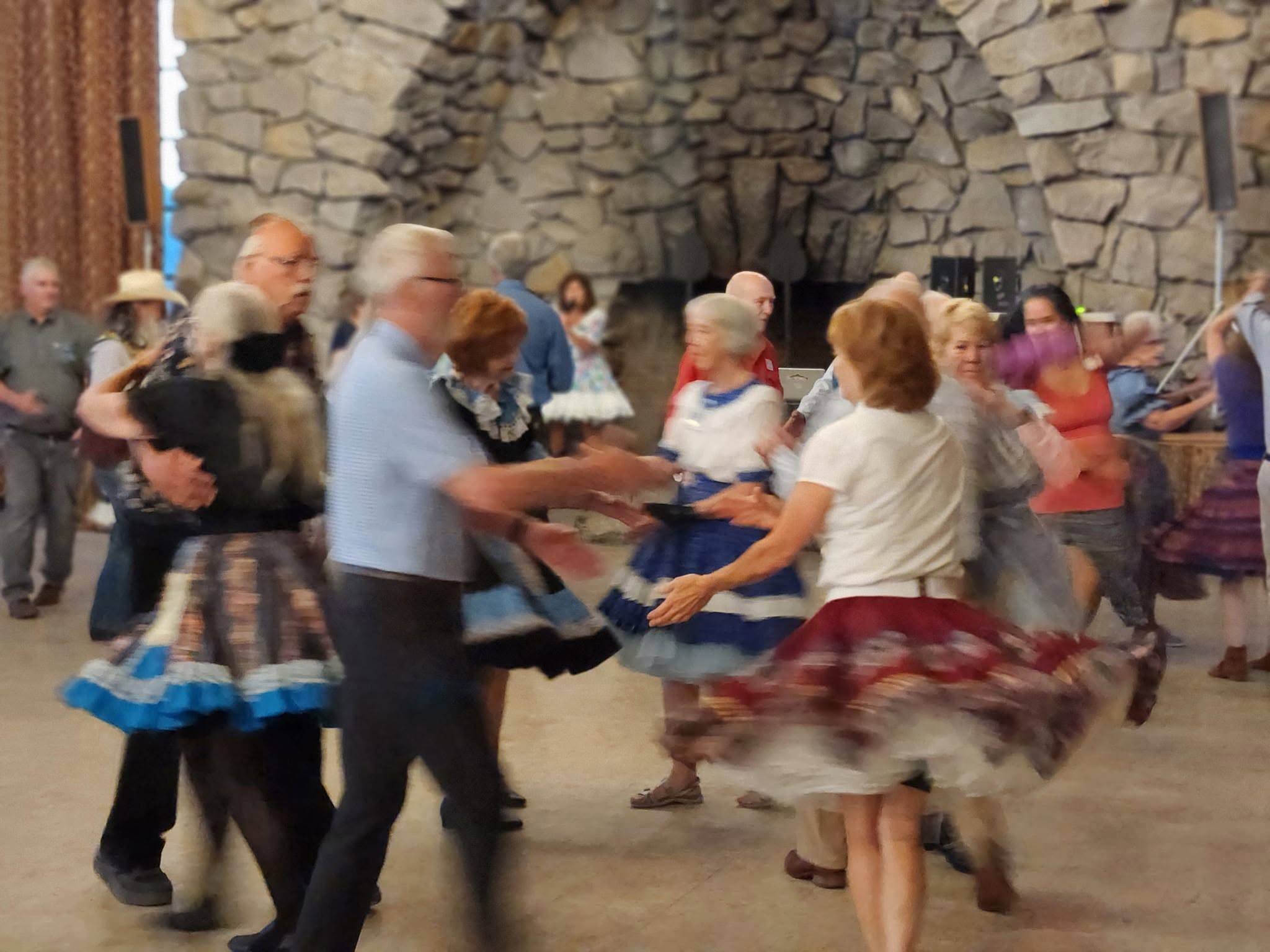 Dancers turning together in front of the lodge fireplace